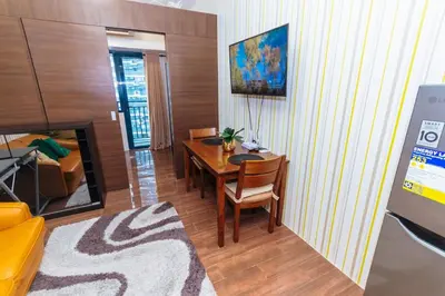 a living room with a table and a couch at Makati Bliss Designer Stay Pool gym park Net300 makati 1767 in Manila