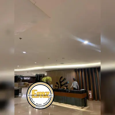 a man standing at the counter of a hotel lobby at EMZ SHORE2 Staycation 18 in Manila