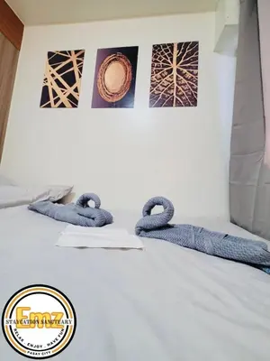 a bed with three blue knitted snakes on it at EMZ SHORE2 Staycation 18 in Manila