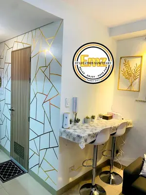 a bar in a room with a counter with stools at EMZ SHORE2 Staycation 18 in Manila