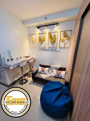 a living room with a couch and a table at EMZ SHORE2 Staycation 18 in Manila