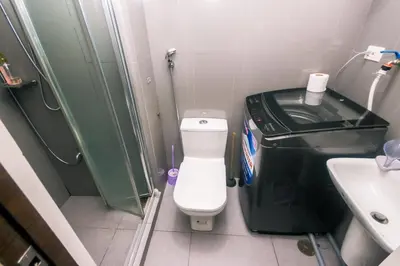 a small bathroom with a toilet and a shower at Metro Paradise 1BR Comfort Makati swim gym park 300MB 2320 in Manila