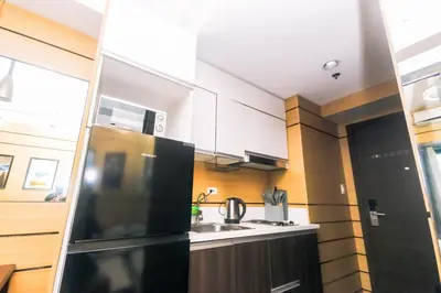 a kitchen with a black refrigerator and a sink at Metro Paradise 1BR Comfort Makati swim gym park 300MB 2320 in Manila