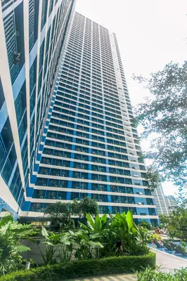a tall building with trees in front of it at Metro Paradise 1BR Comfort Makati swim gym park 300MB 2320 in Manila