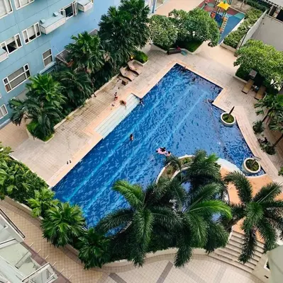 an overhead view of a large swimming pool with palm trees at 1BR Suite Ridgewood Towers Near BGC Airport #RW17-1 in Manila