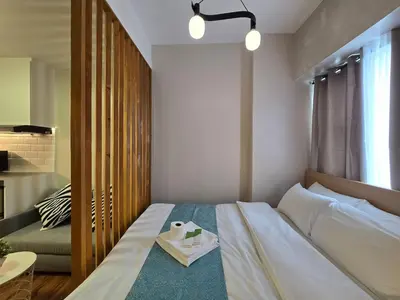 a bedroom with a bed with a tray of food on it at 1BR Suite Ridgewood Towers Near BGC Airport #RW17-1 in Manila