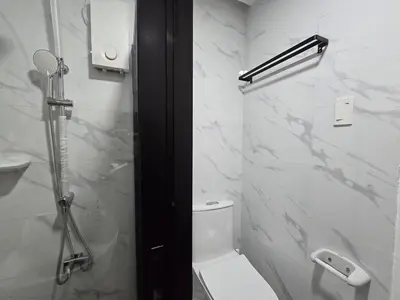 a white bathroom with a shower and a toilet at 1BR Suite Ridgewood Towers Near BGC Airport #RW17-1 in Manila