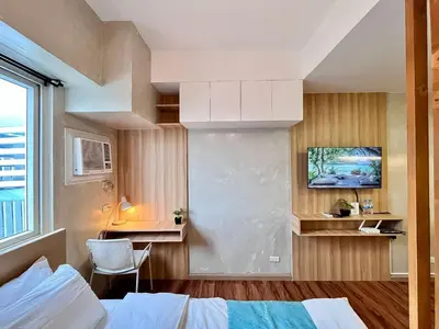 a bedroom with a bed and a tv on a wall at 1BR Suite Ridgewood Towers Near BGC Airport #RW17-1 in Manila