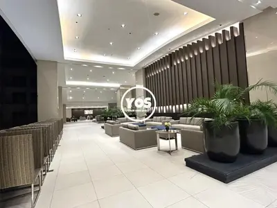 a lobby with couches and plants in a building at Your Own Space Staycation in MOA in Manila