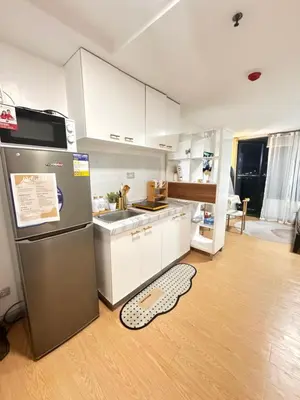 a kitchen with a stainless steel refrigerator on a wooden floor at Coziey Inn in Manila