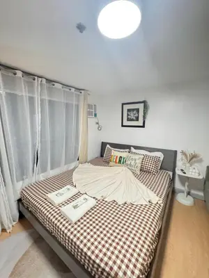 a bedroom with a bed with a checkered blanket at Coziey Inn in Manila