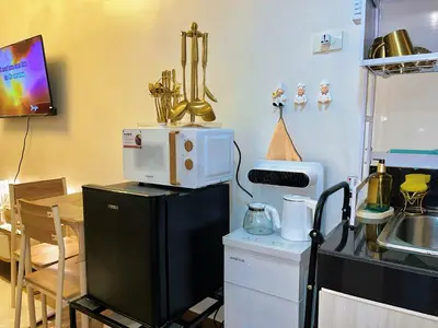 a kitchen with a microwave on top of a refrigerator at Auberge Condotels B at SMDC Hope Residences in Trece Martires