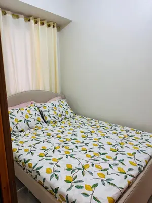 a bedroom with a bed with a bedspread with yellow flowers at MOA Shore 3 One Bedroom Family Suite with Balcony in Manila