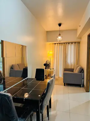a living room with a table and a couch at MOA Shore 3 One Bedroom Family Suite with Balcony in Manila