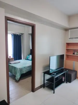 a room with a mirror and a television and a bed at Rooms in Pasay City At Two Palm Tree Villas in Manila