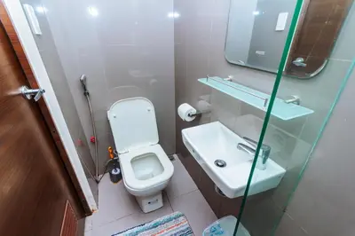 a bathroom with a white toilet and a sink at Modern One BR Makati Condo Swim Gym Parking Netflix Fast 2428 in Manila