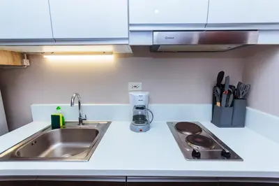 a kitchen with a sink and a counter top at Modern One BR Makati Condo Swim Gym Parking Netflix Fast 2428 in Manila