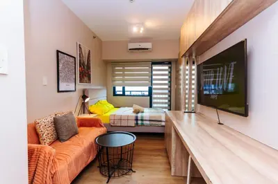 a living room with a couch and a bed at Modern One BR Makati Condo Swim Gym Parking Netflix Fast 2428 in Manila