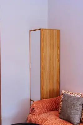 a bed with a wooden cabinet and a pillow at Modern One BR Makati Condo Swim Gym Parking Netflix Fast 2428 in Manila