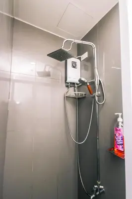 a shower with a shower head in a bathroom at Netflix & Chill Stylish Makati condo gym swim park internet fast 2474 in Manila