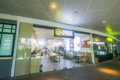 a restaurant with people sitting at tables in a building at Netflix & Chill Stylish Makati condo gym swim park internet fast 2474 in Manila