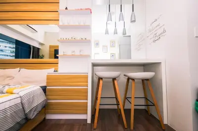 a bedroom with a bed and two bar stools at Netflix & Chill Stylish Makati condo gym swim park internet fast 2474 in Manila