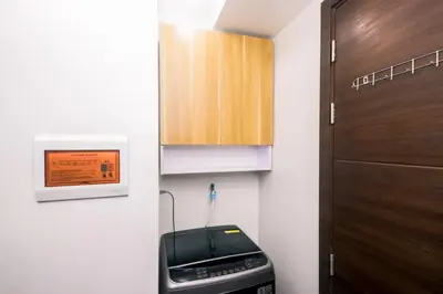 a small kitchen with a toaster and a cabinet at Netflix & Chill Stylish Makati condo gym swim park internet fast 2474 in Manila