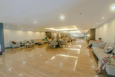 a lobby with people sitting on couches and tables at Urban Luxe 1BR Makati central gym swim Park Fast Internet MB 3301 in Manila