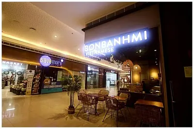 a restaurant with chairs and tables in front of a store at City Best Designer 1BR Makati Fast internet Gym Swim Park 2050 in Manila
