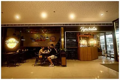 two people sitting at a table in a restaurant at City Best Designer 1BR Makati Fast internet Gym Swim Park 2050 in Manila