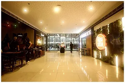 a man walking down a hallway in a restaurant at City Best Designer 1BR Makati Fast internet Gym Swim Park 2050 in Manila