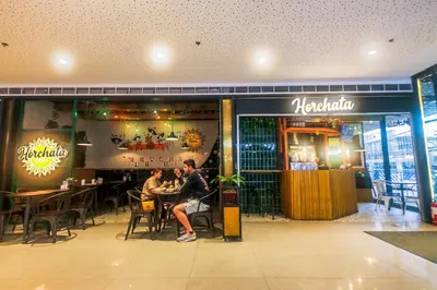 a group of people sitting at tables in a restaurant at City Best Designer 1BR Makati Fast internet Gym Swim Park 2050 in Manila