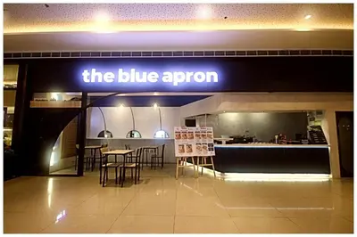 a blue aron sign in a restaurant with tables and chairs at City Best Designer 1BR Makati Fast internet Gym Swim Park 2050 in Manila