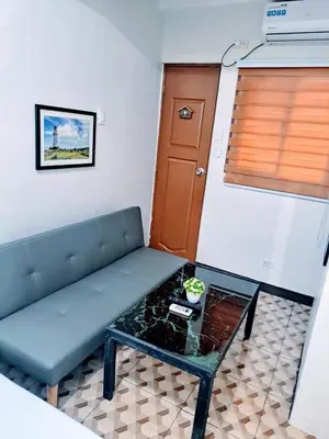 a living room with a couch and a table at Eurica transient Inn Near Terminal 3 in Manila