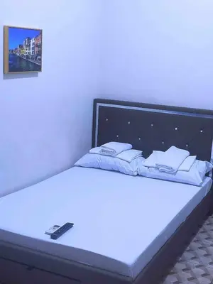 a white bed with a remote control on it at Eurica transient Inn Near Terminal 3 in Manila