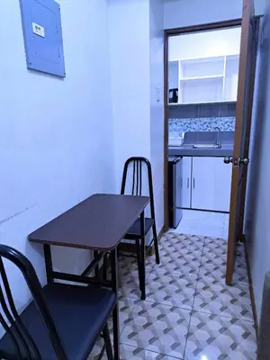 a table and chairs in a room with a kitchen at Eurica transient Inn Near Terminal 3 in Manila