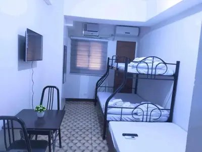 a small room with two bunk beds and a table at Eurica transient Inn Near Terminal 3 in Manila