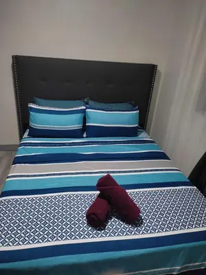 a red teddy bear sitting on a bed at LDN Pinecrest Two-room Suite in Manila
