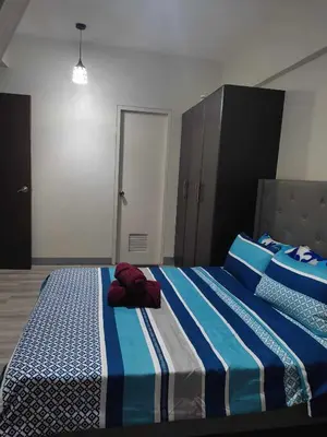 a bedroom with two beds with blue and white sheets at LDN Pinecrest Two-room Suite in Manila