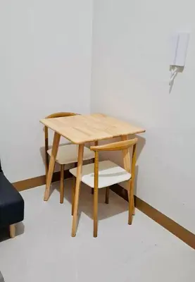 a wooden table with a chair and a table and a table at City Escape in Manila