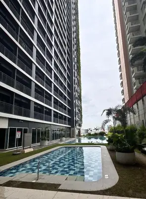 a swimming pool in front of a tall building at City Escape in Manila