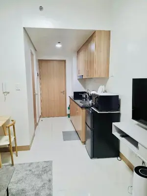 a kitchen with black appliances and wooden cabinets at City Escape in Manila