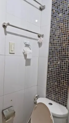 a bathroom with a toilet and a tiled wall at MEZZA TOWER 2 SMARTTV 43inch in Manila