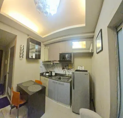 a small kitchen with a table and a refrigerator at MEZZA TOWER 2 SMARTTV 43inch in Manila