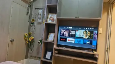 a television in a cabinet in a room at MEZZA TOWER 2 SMARTTV 43inch in Manila