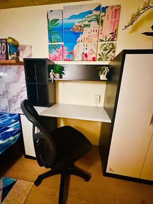 a desk with a computer monitor and a chair at Cattleya Hearthstone in Manila