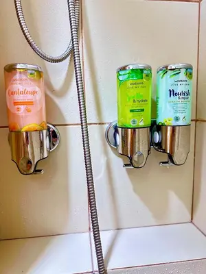a bathroom wall with two canisters on a wall at Cattleya Hearthstone in Manila