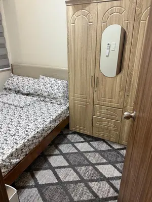 a bedroom with a bed next to a wooden cabinet at Fred Erick Staycation in Manila