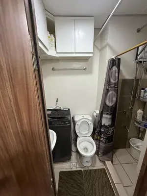 a small bathroom with a toilet and a sink at Fred Erick Staycation in Manila
