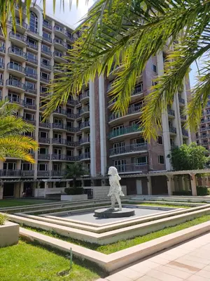 a statue in front of a large apartment building at Facing Pool w Balcony MOA BP1741 in Manila